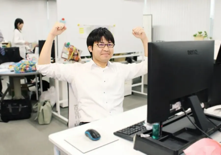 オフィスでガッツポーズをする社員