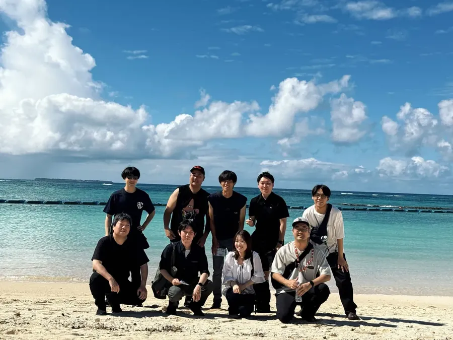 社員旅行で訪れた海辺での集合写真