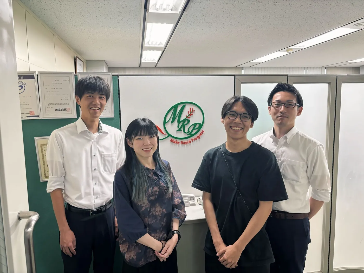 ロゴの前に並ぶ社員たち