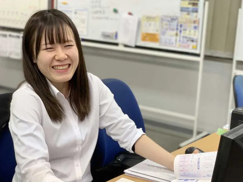 デスクで笑顔を見せるWebサイト制作の社員