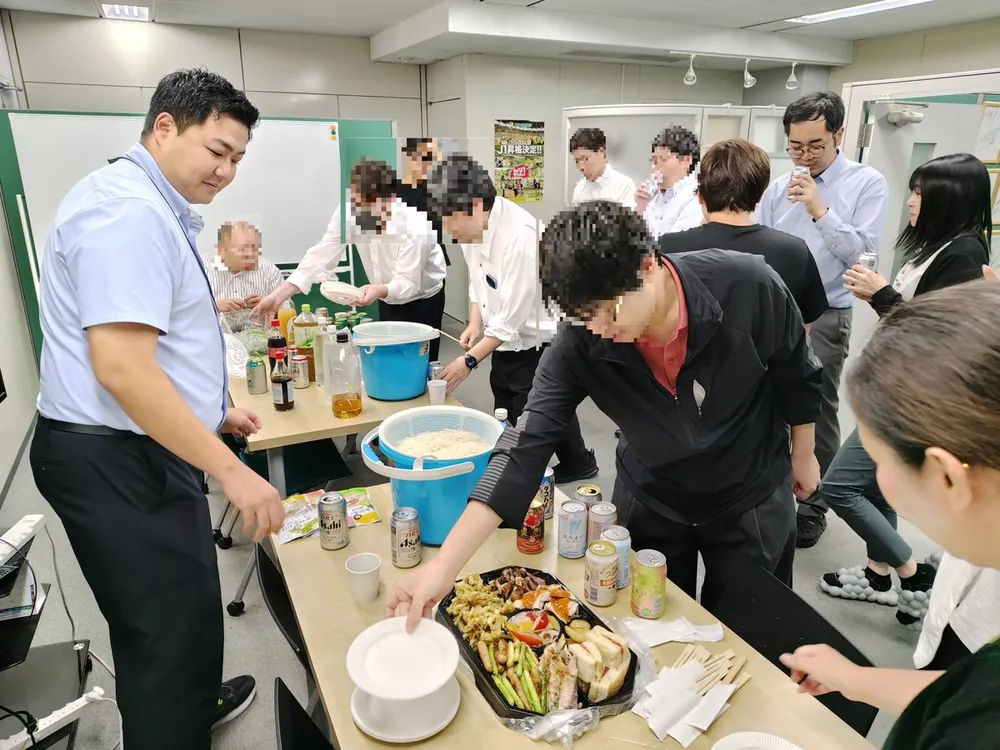 オフィスで料理を囲む社員たち