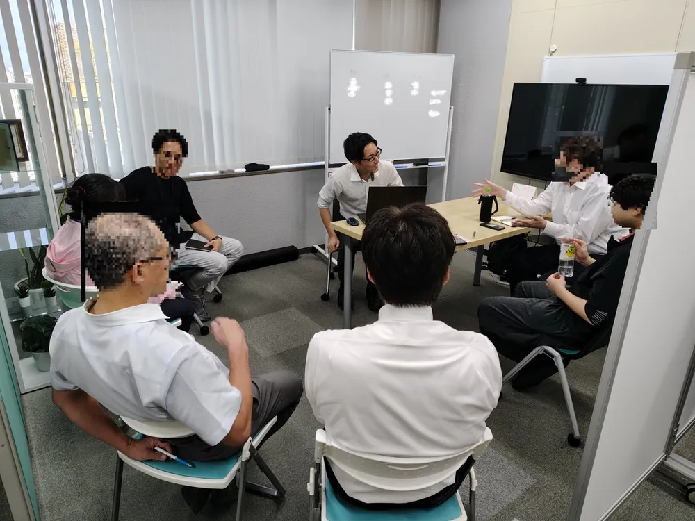 テーブルを囲んで話し合う社員たち