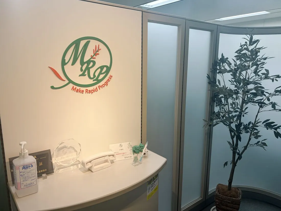 ロゴと観葉植物のあるエントランス