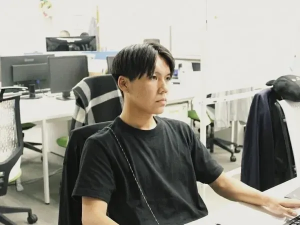パソコンに向かって仕事をするYYさん